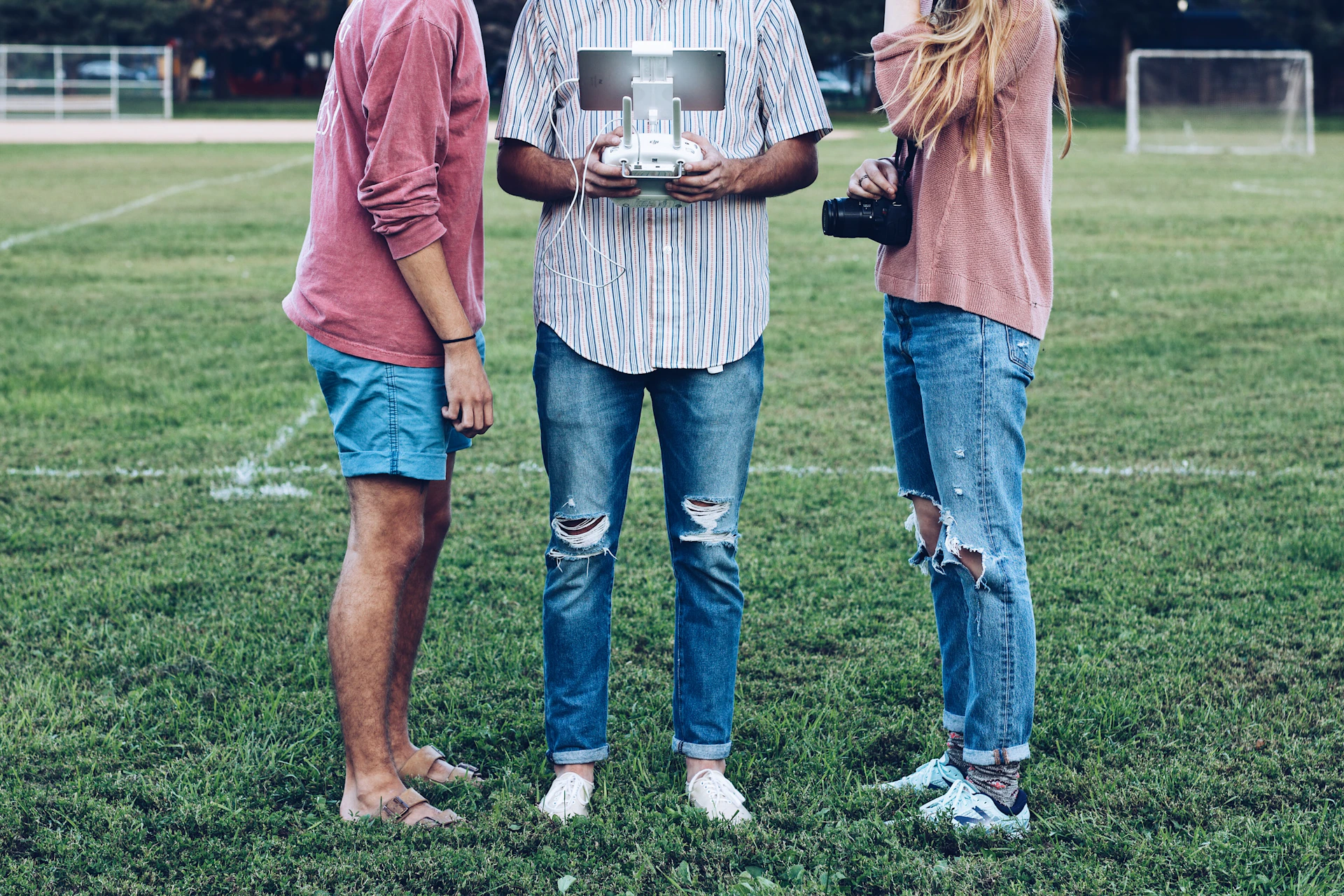 a group of people standing on a grass field