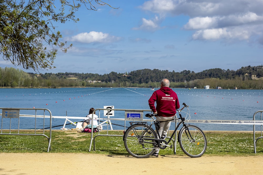 a man on a bicycle by a lake