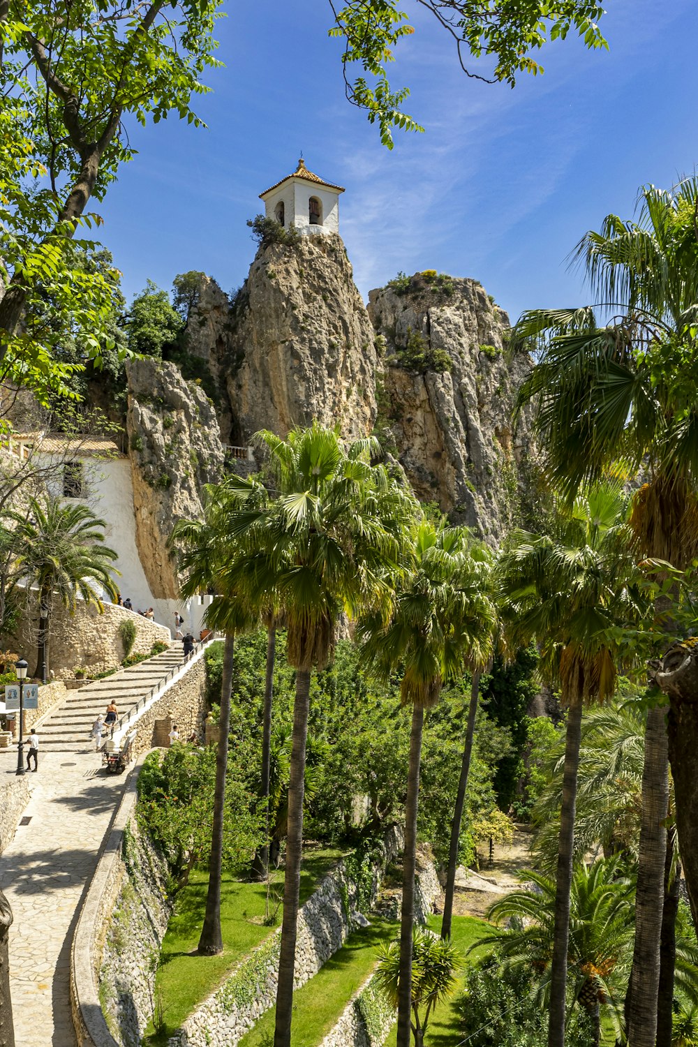 a stone building with a tower and trees in front of it