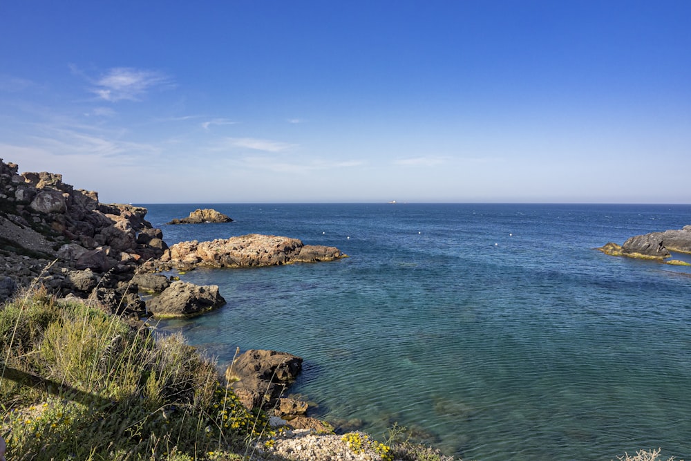 a rocky beach with blue water