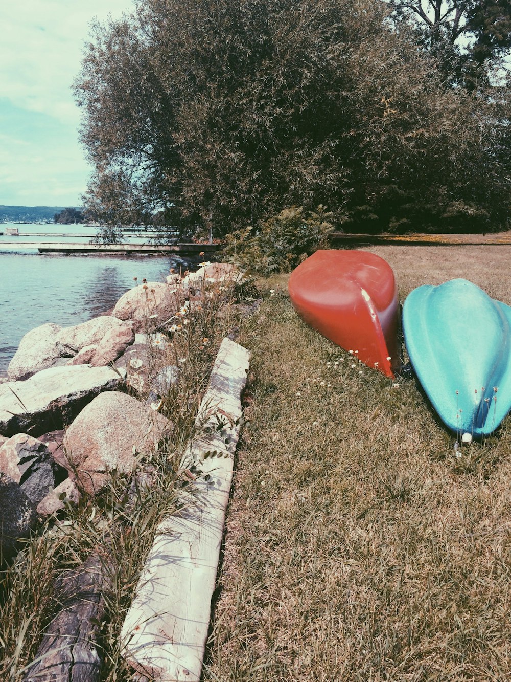 a group of buckets on a stone wall by a body of water