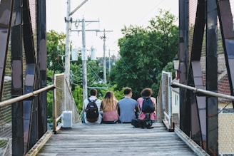 a group of people sitting on a bridge