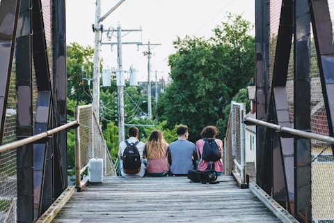 a group of people sitting on a bridge