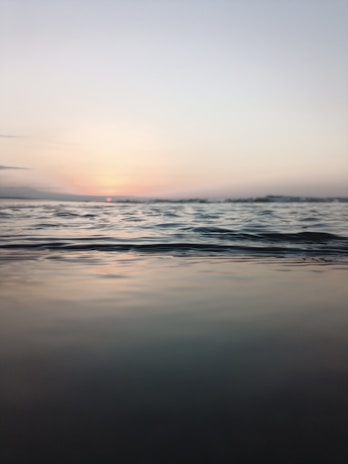 A serene seascape painting capturing gentle waves under a soft sunset.