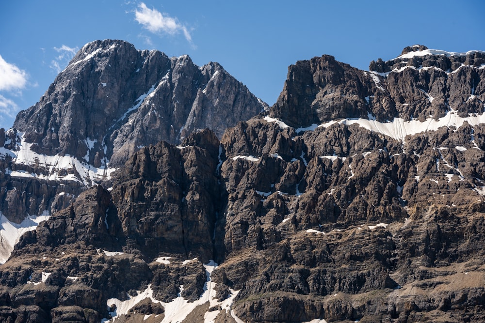 Una montaña rocosa con nieve