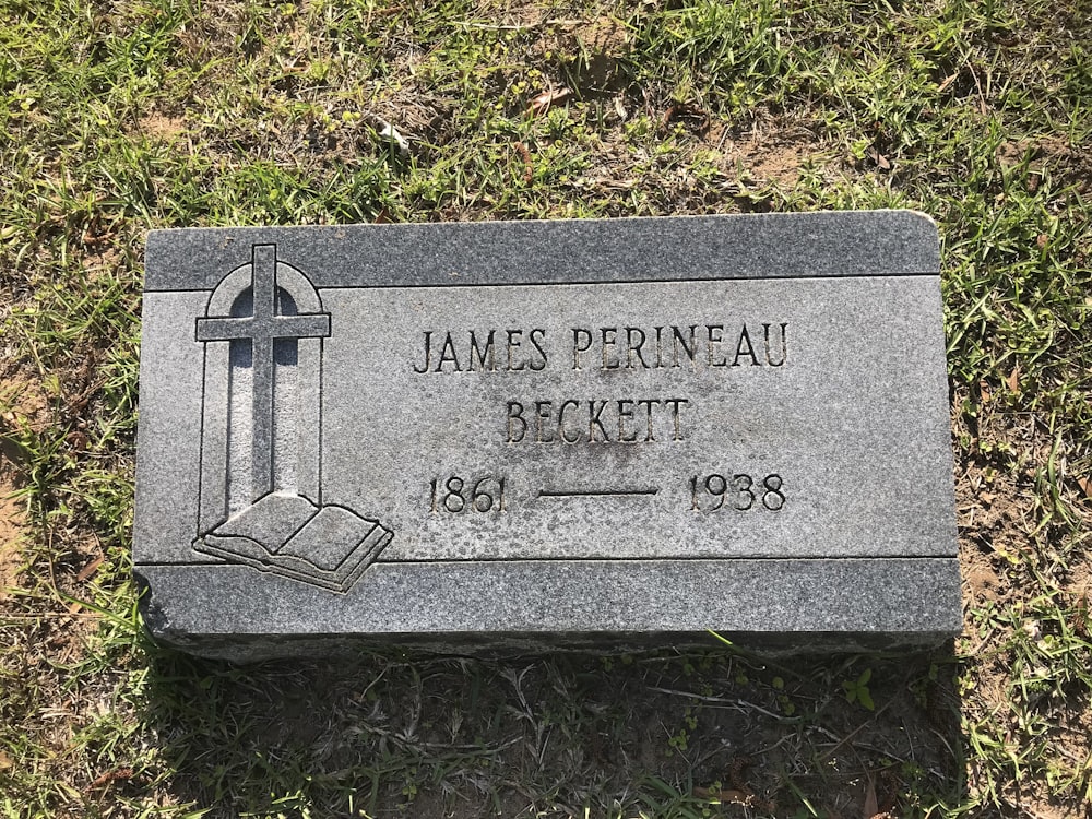 a tombstone in a grassy area