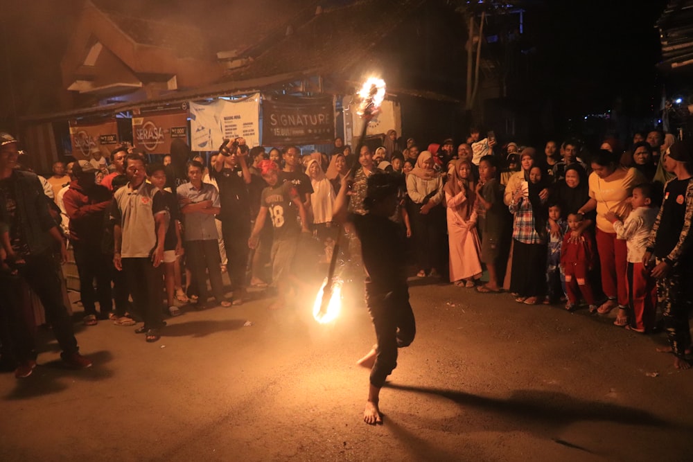 a person holding a fire in front of a crowd of people