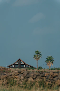 A luxury Palm Beach home with a freshly installed roof under a clear blue sky.