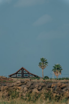Exterior view of a luxury desert home featuring large windows and stone accents under a clear blue sky.