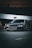 A sleek, black sports car is parked in an urban environment, with a large advertisement billboard in the background. The car's design features sharp, angular lines and a glossy finish, reflecting the ambient light. The overall setting has a slightly moody and dramatic atmosphere.