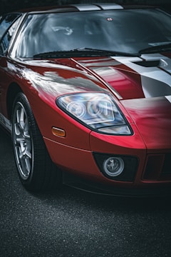 A sleek red sports car with a custom Forza livery featuring bold stripes and sponsor logos.