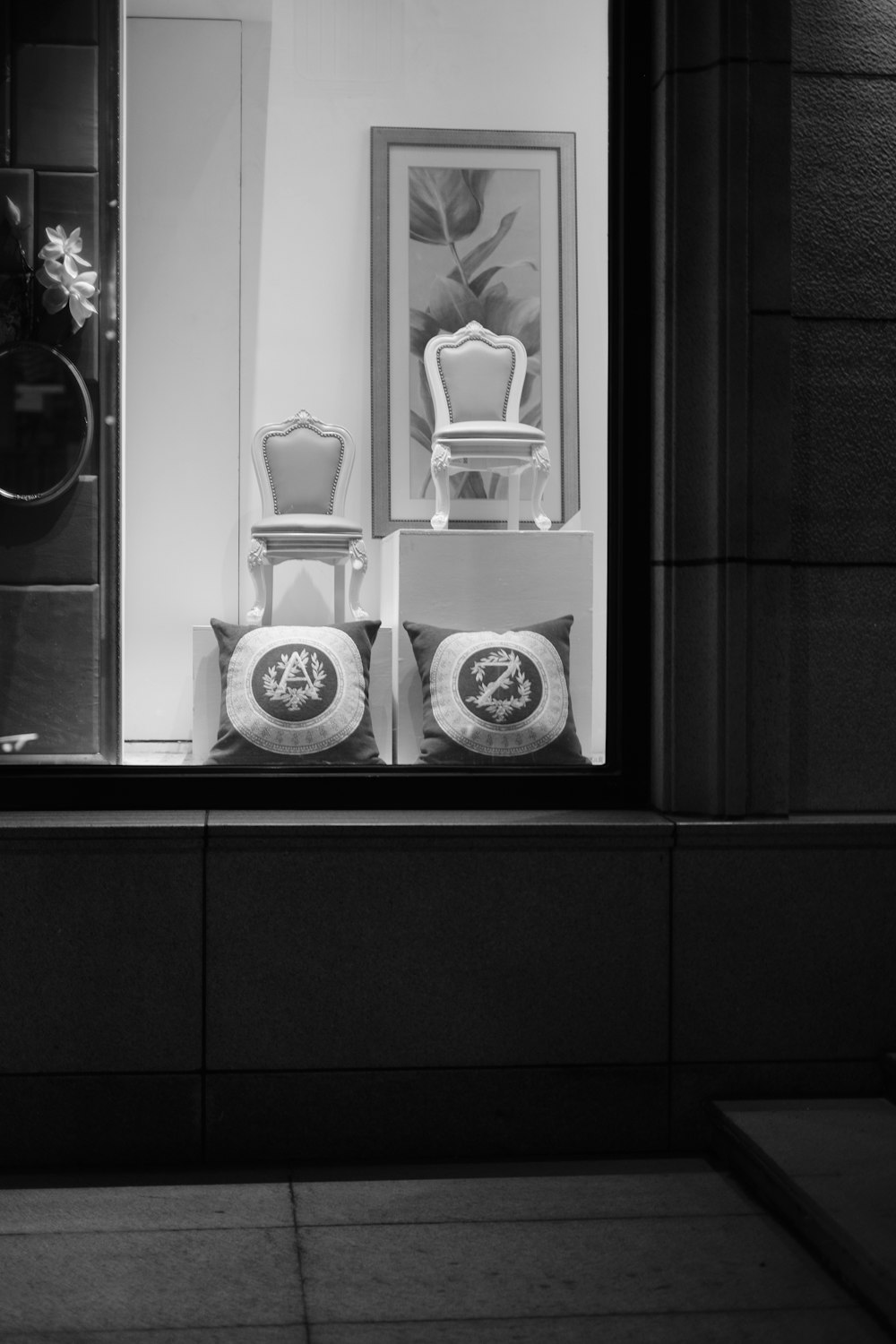 a black and white photo of a bathroom with a mirror and a vase