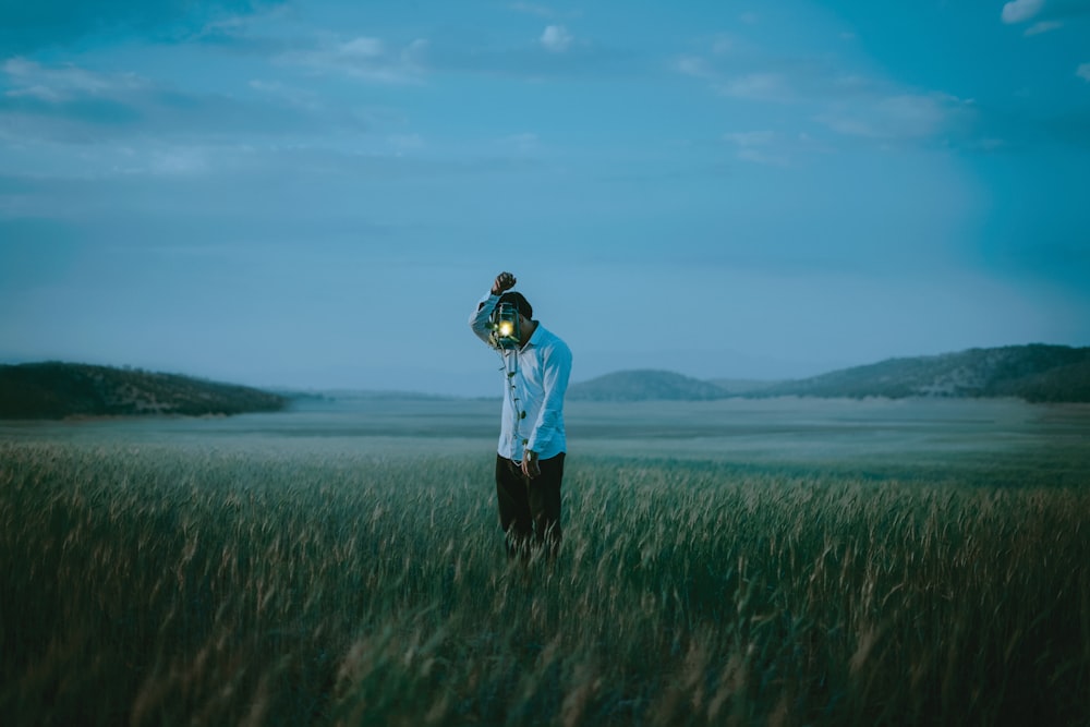 a man holding a baby in a field of grass