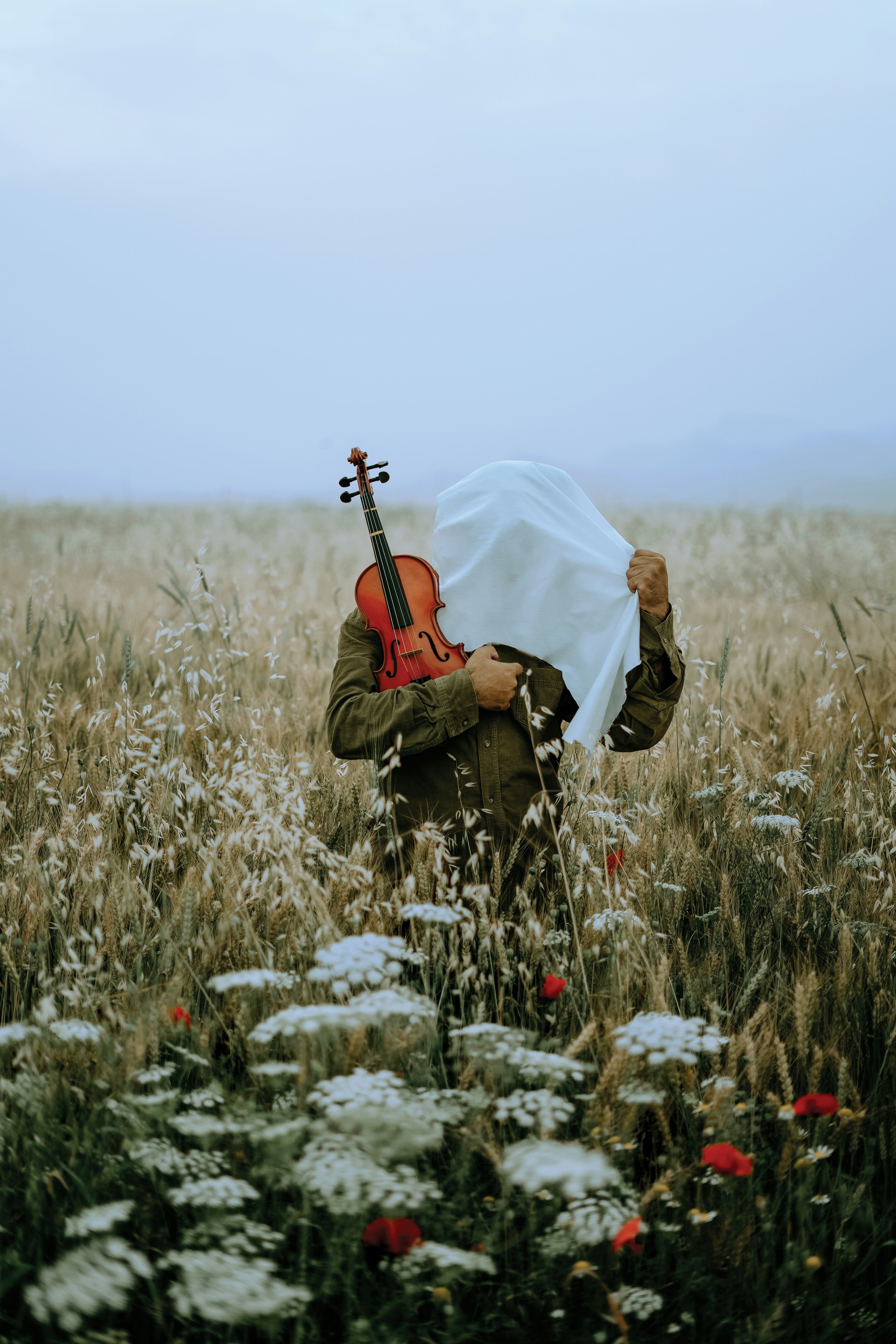 a person kneeling in a field with a guitar
