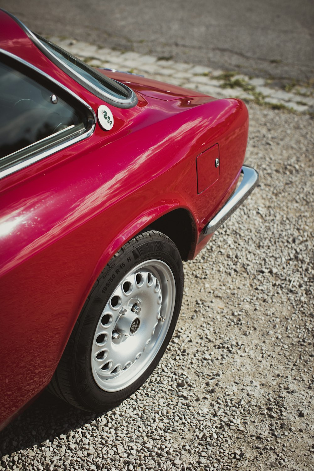 a red car parked on gravel