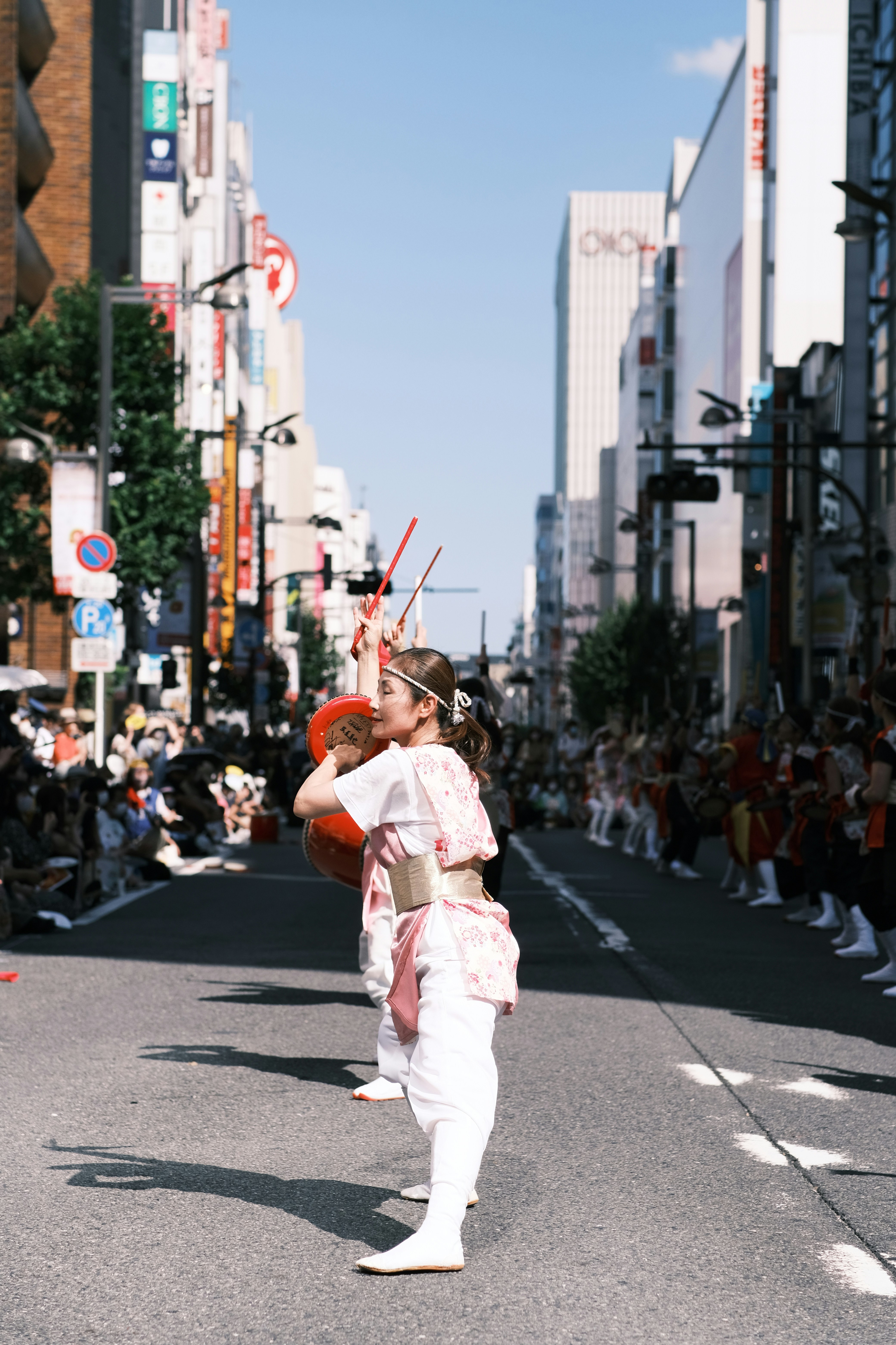 a man and woman kissing on a street with a crowd watching