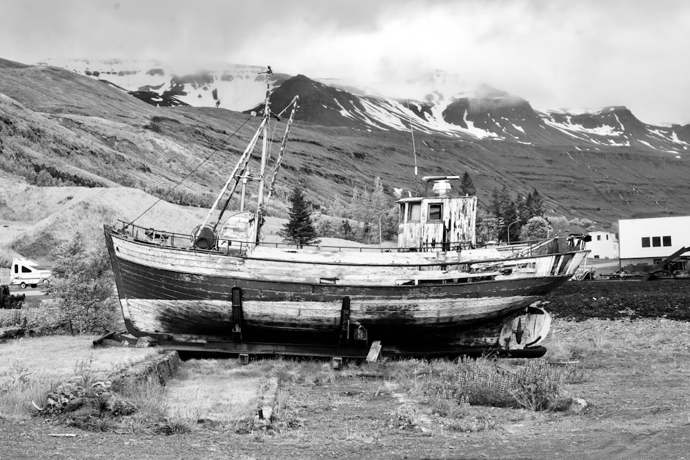 a boat sits on the shore of a lake