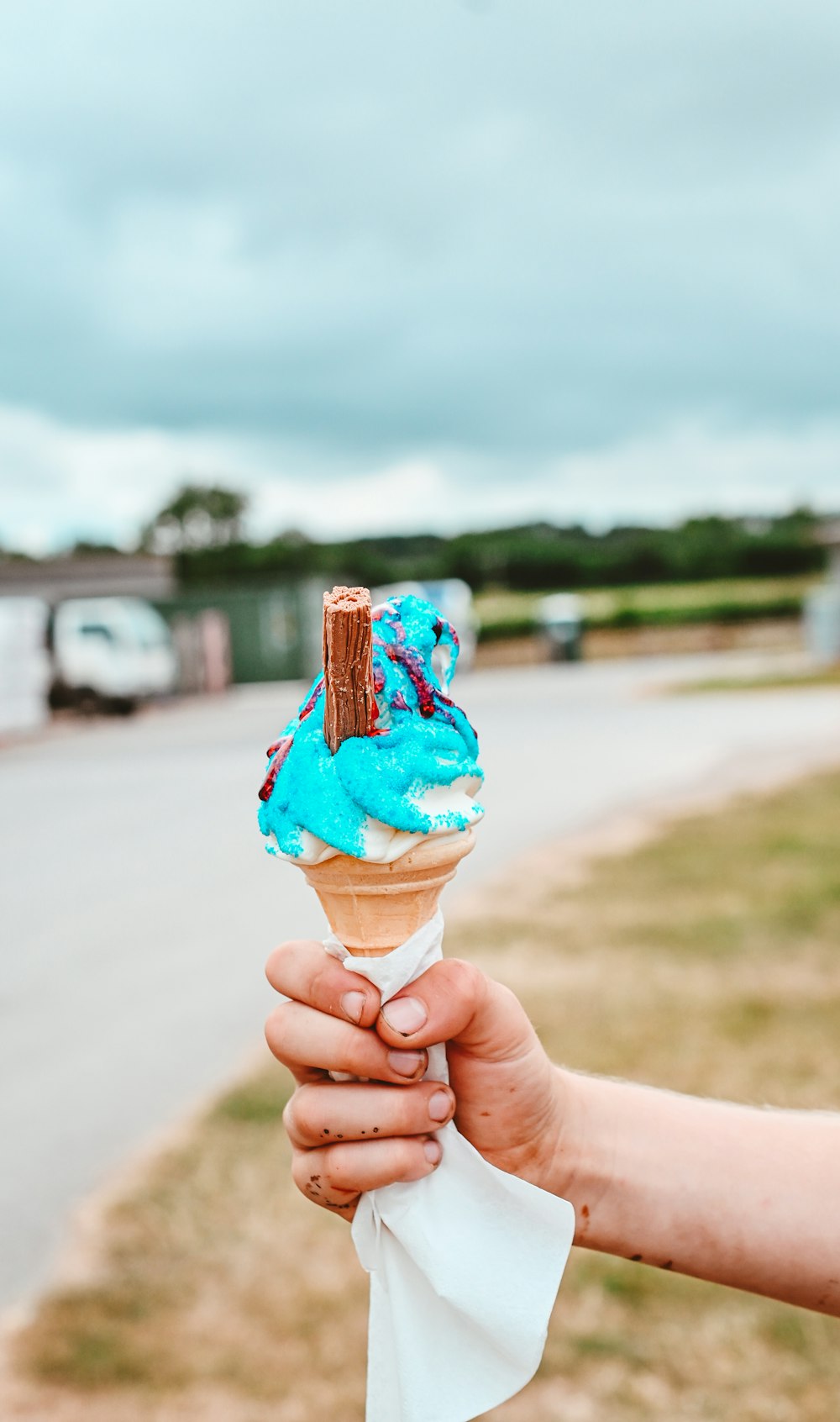 Un primer plano de una mano sosteniendo un cono de helado