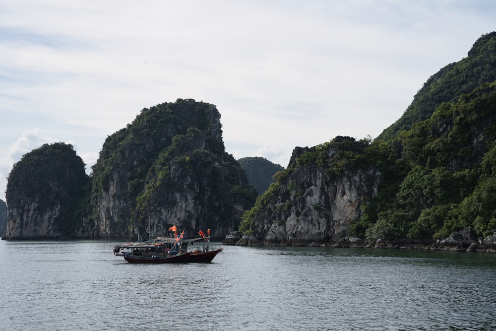 a boat in the water by a rocky cliff