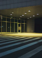 Security guard attentively monitoring a commercial building entrance during the evening.