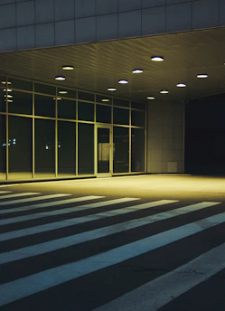 Security guard attentively monitoring a commercial building entrance during the evening.