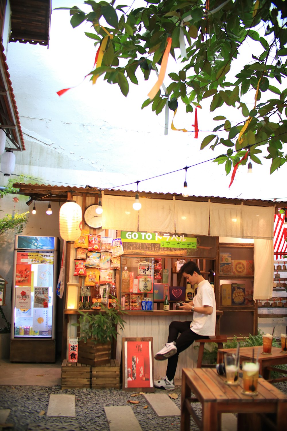 a person sitting on a stool outside a shop