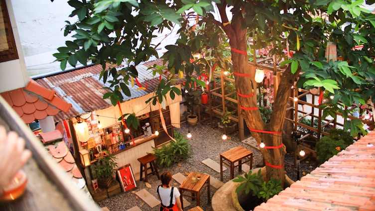 A cozy mobile bar setup under string lights with wooden barrels and colorful Mexican decorations.