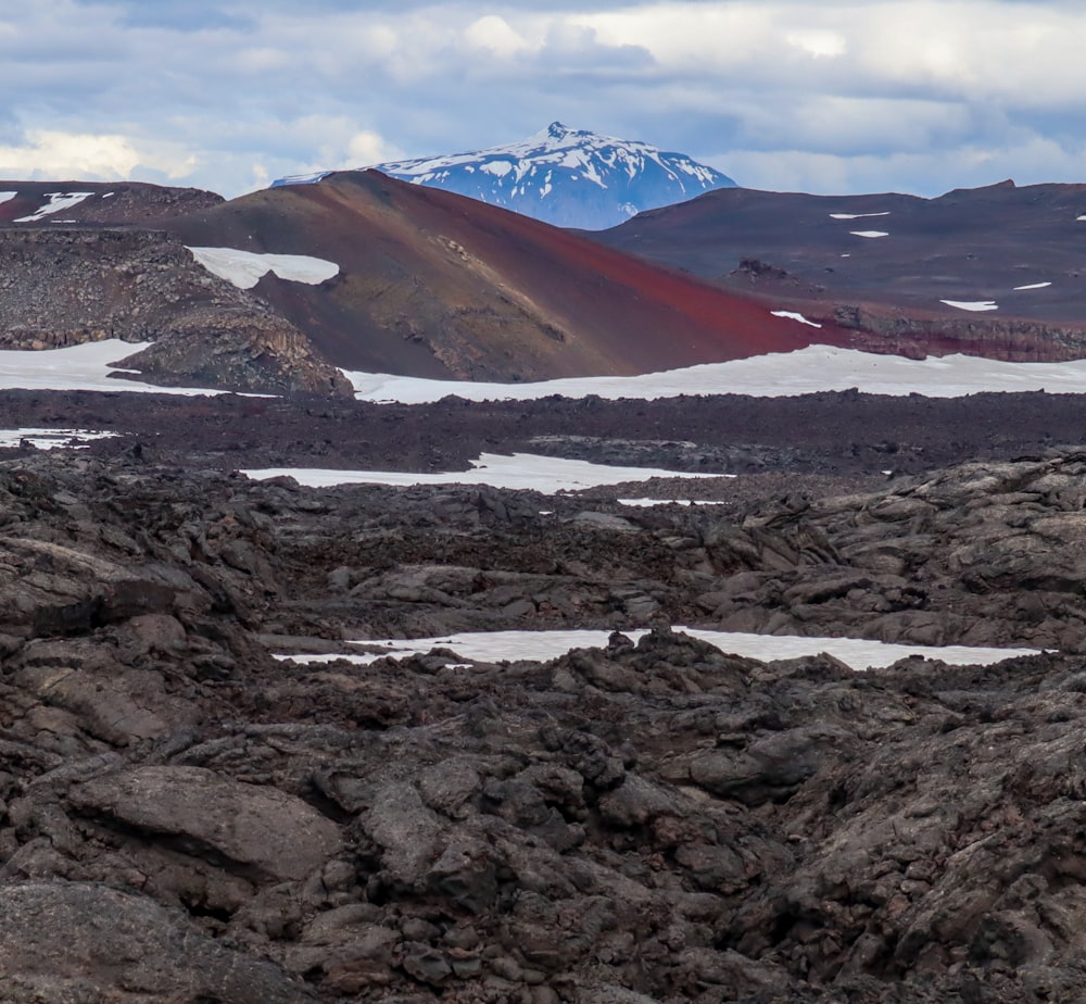 a rocky landscape with a mountain in the background