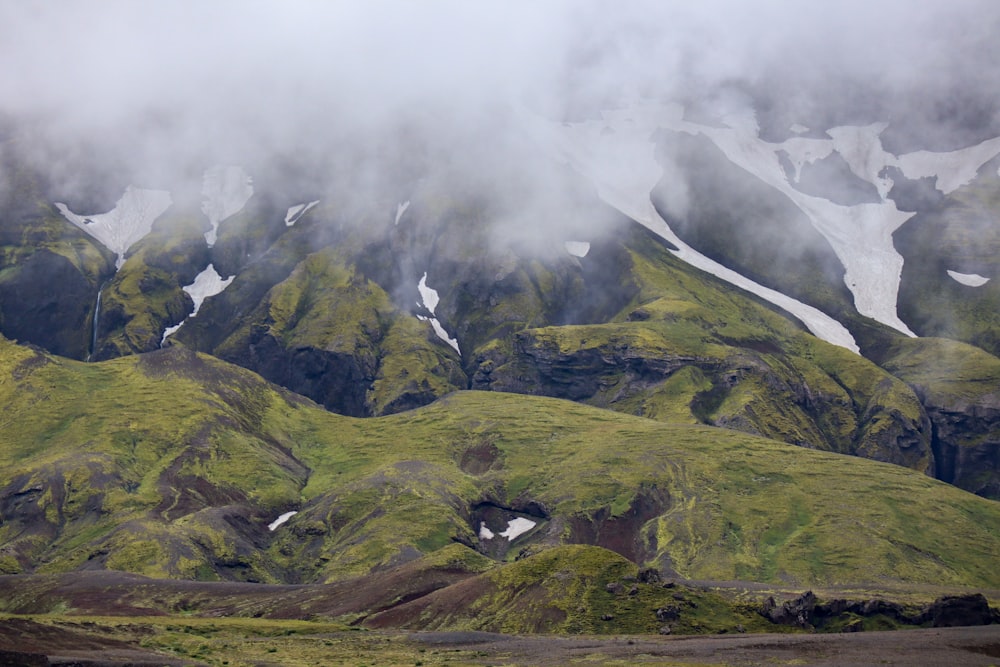 Ein grasbewachsener Berg mit Wolken