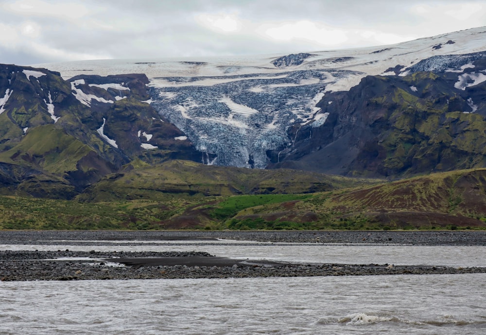 a body of water with mountains in the back