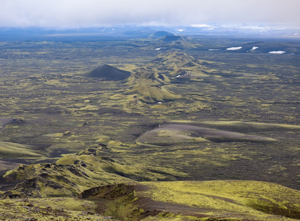 a landscape with hills and a body of water in the distance