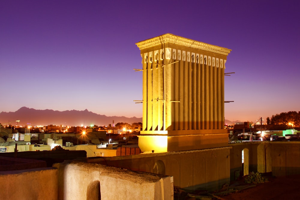 a large cylindrical structure with a city in the background