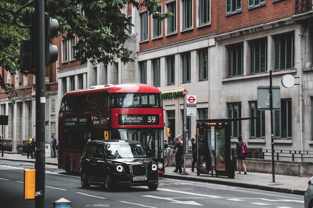 a black car and a red bus on a street