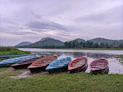 a group of boats sit on the shore of a lake