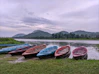 a group of boats sit on the shore of a lake