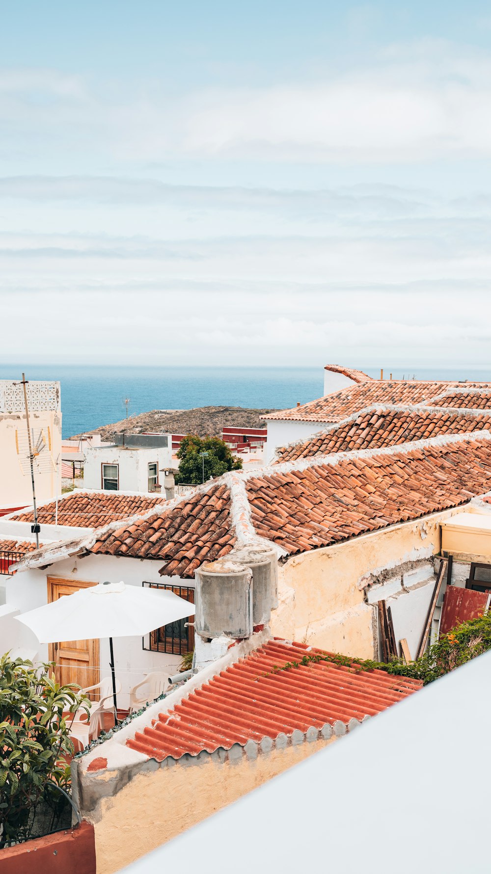 a group of rooftops with a body of water in the background