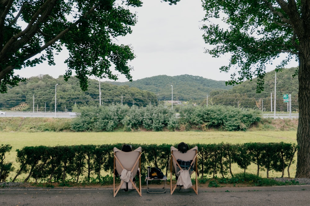 two people sitting in chairs outside