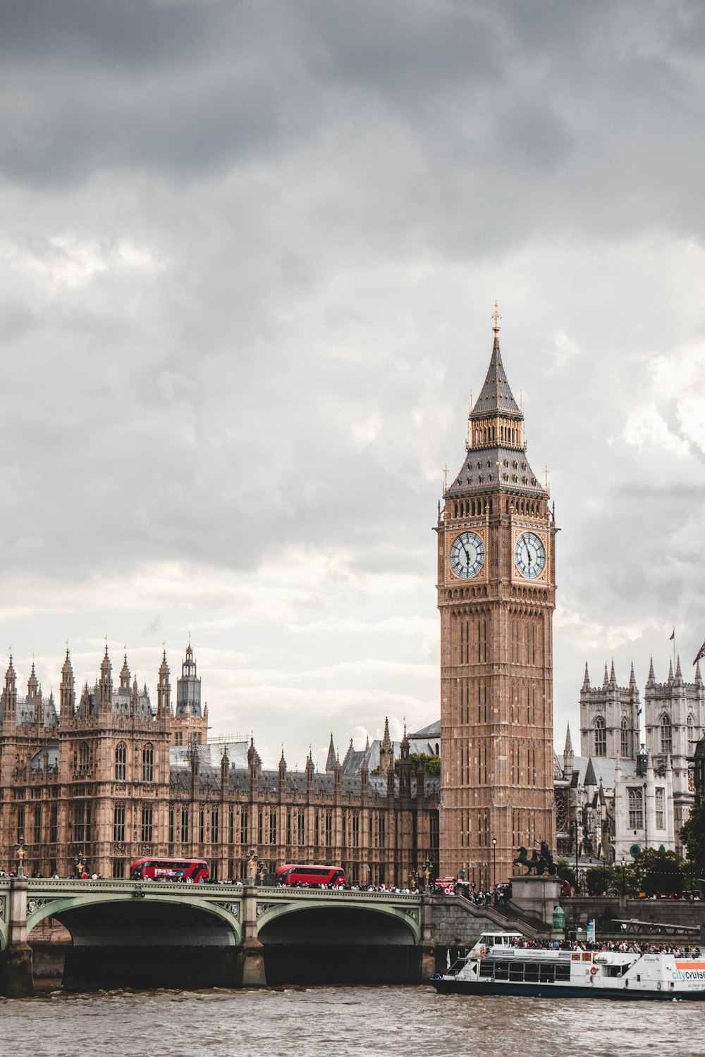 a clock tower next to a river with Big Ben in the background