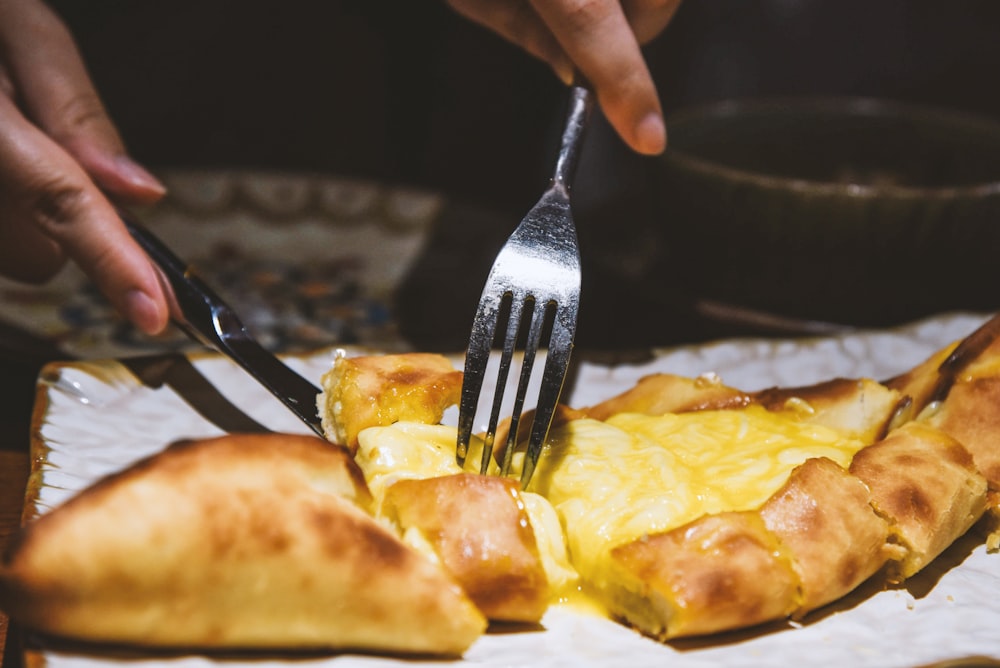 a person cutting a pizza