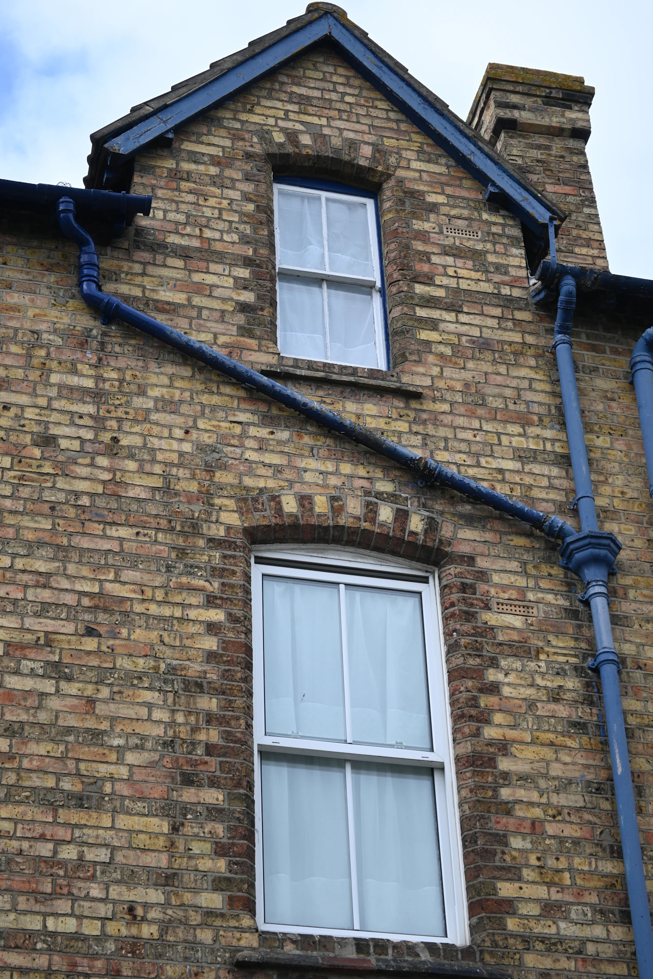 Clean gutters and a downspout directing water away from a house