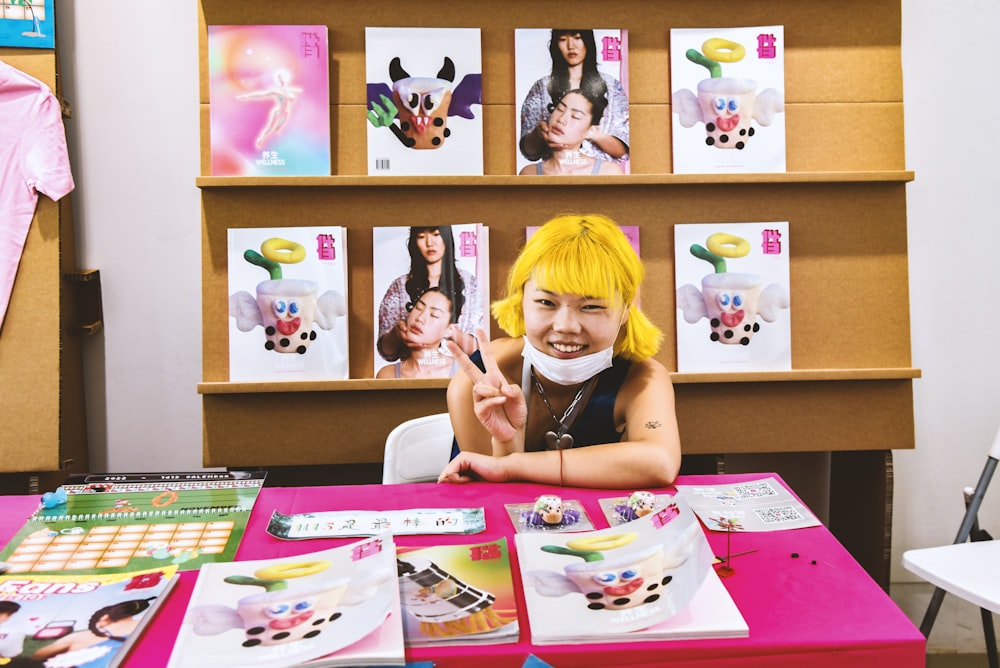 a person sitting at a table with a bunch of books