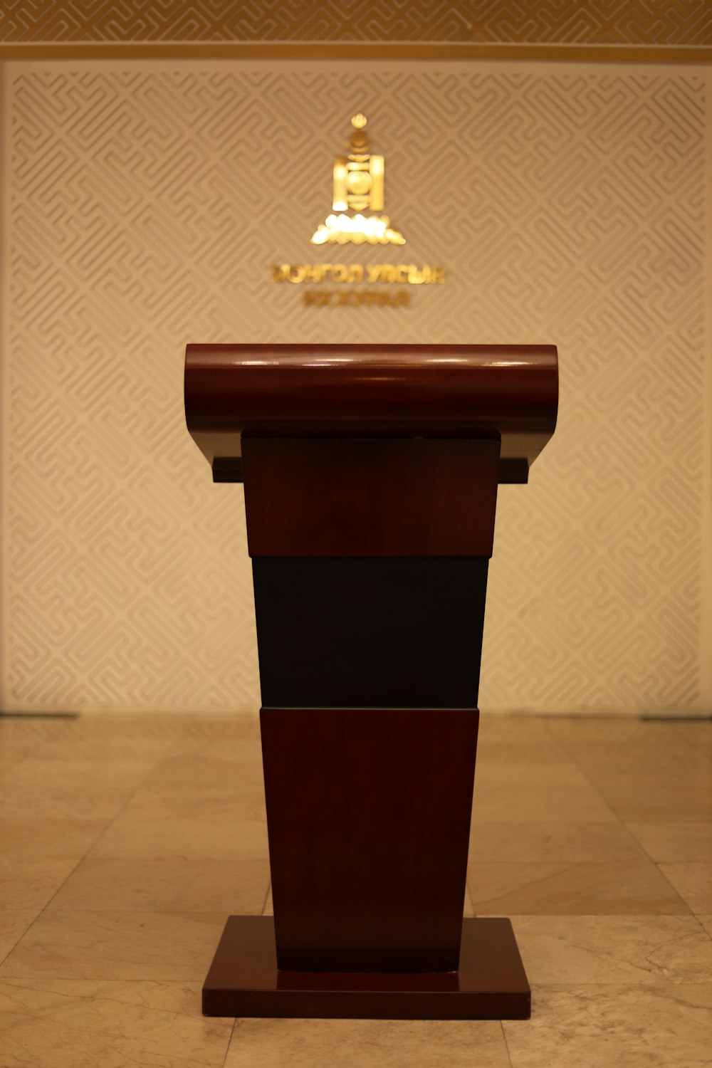 um pedestal preto e dourado com um tampo de ouro e uma coroa de ouro