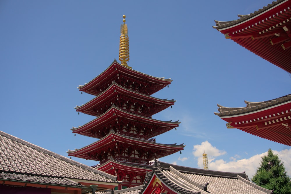a tall tower with red and gold rooftops