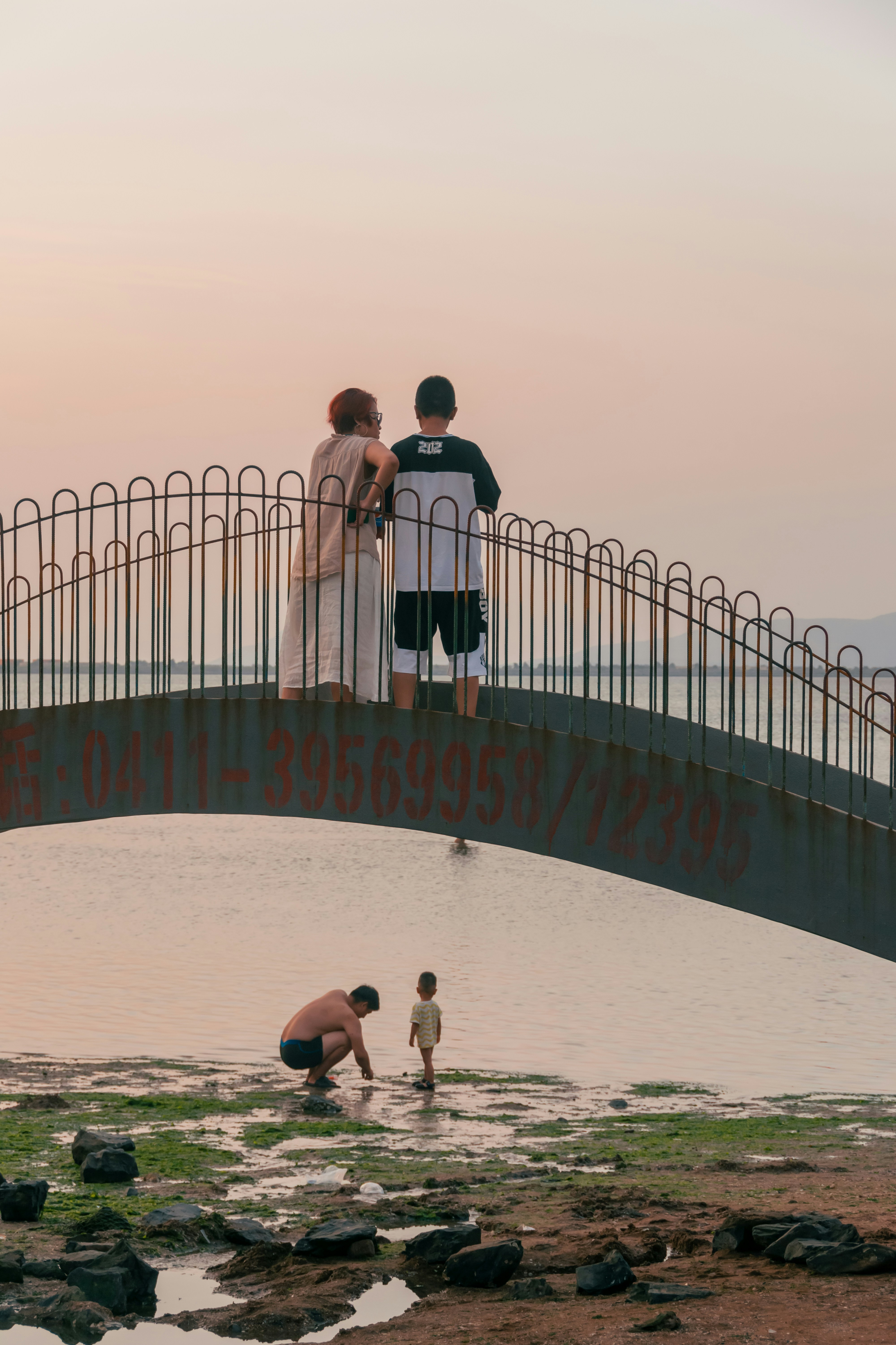 a group of people standing on a bridge over water