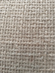 A close-up view of a woven textile fabric showcasing a rough texture with interlaced fibers creating a grid-like pattern.