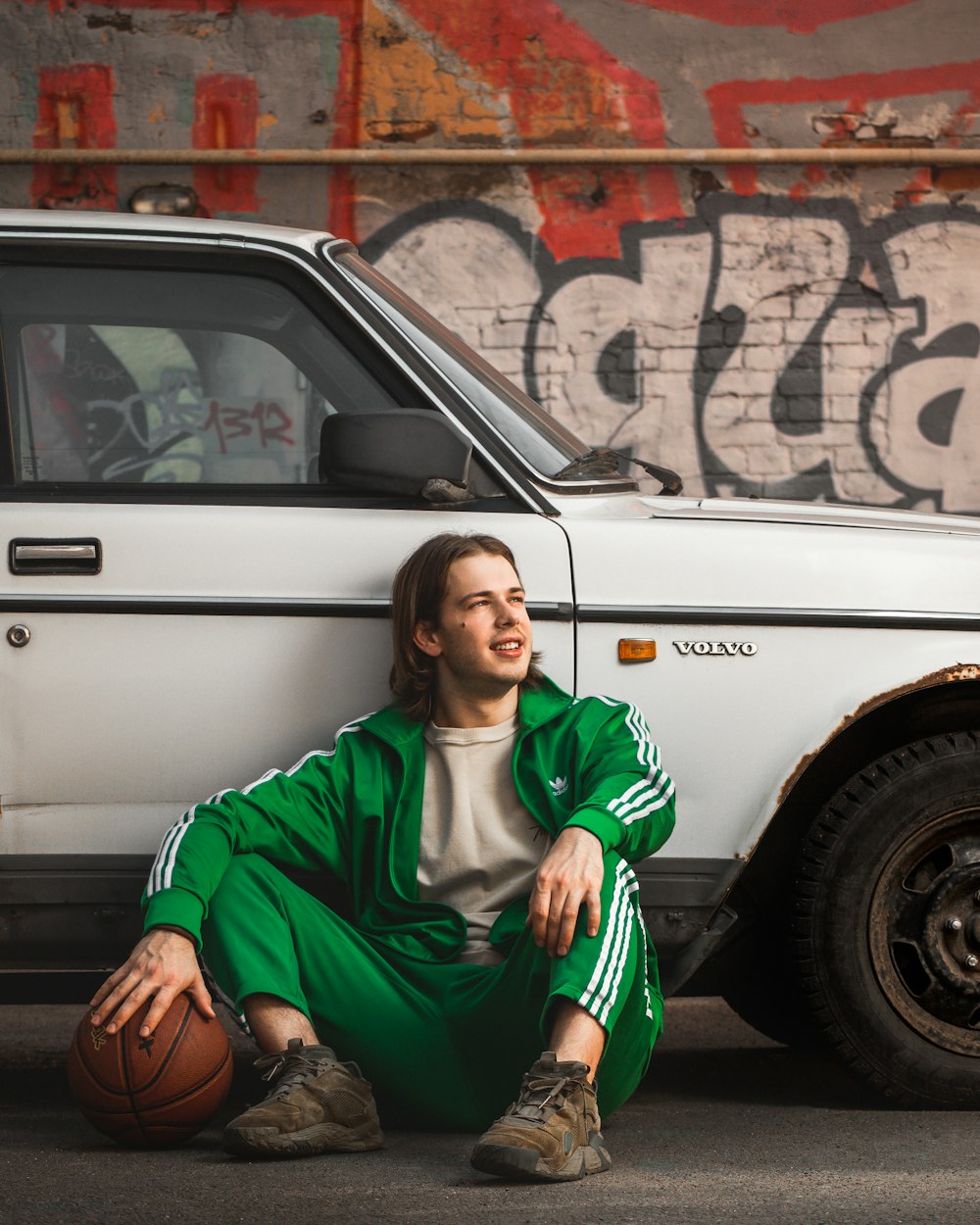 a person sitting on the ground with a basketball