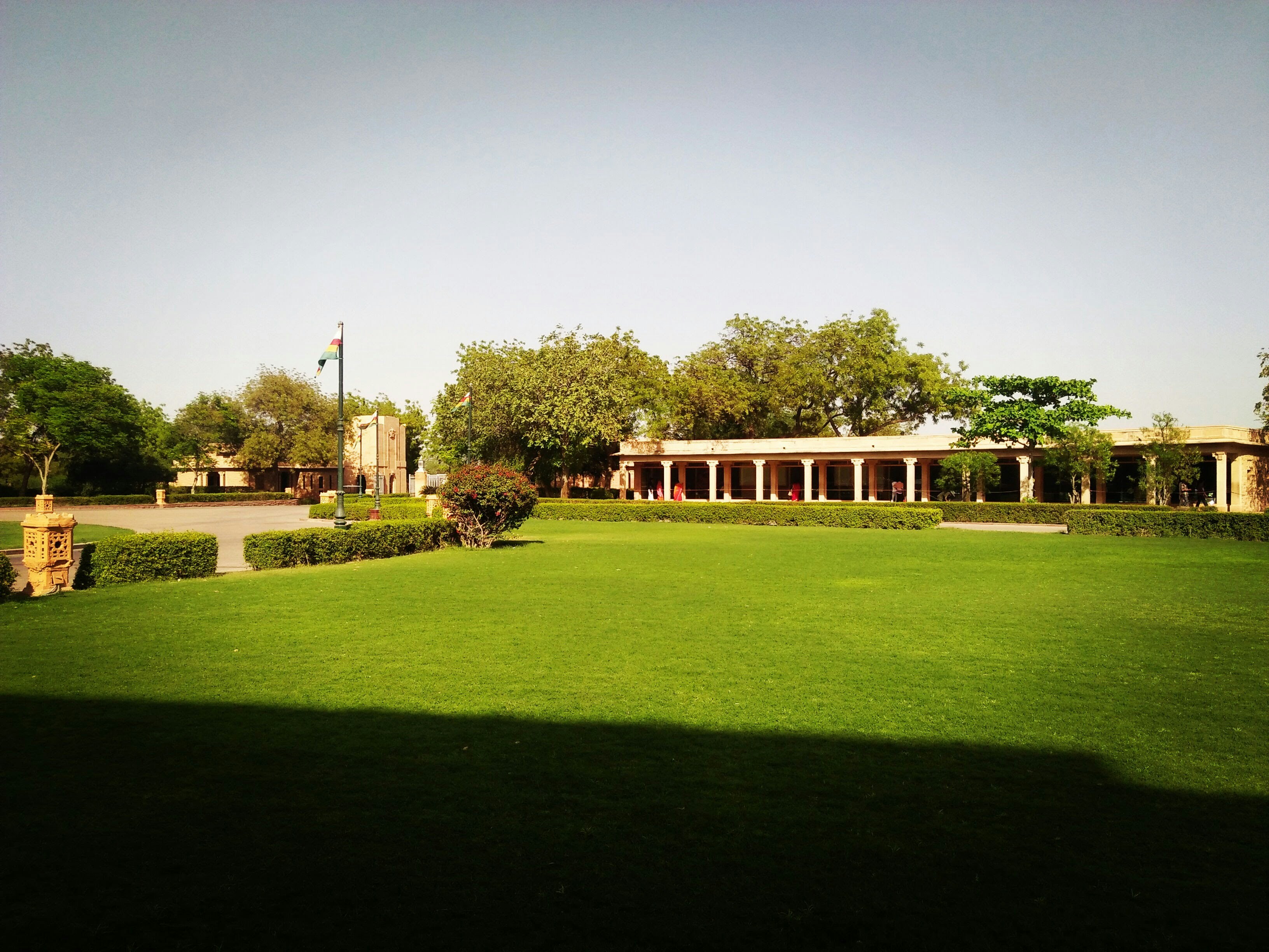 a large green lawn with a building in the background