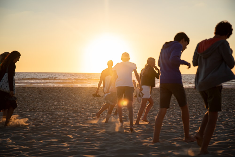 a group of people walking on a beach