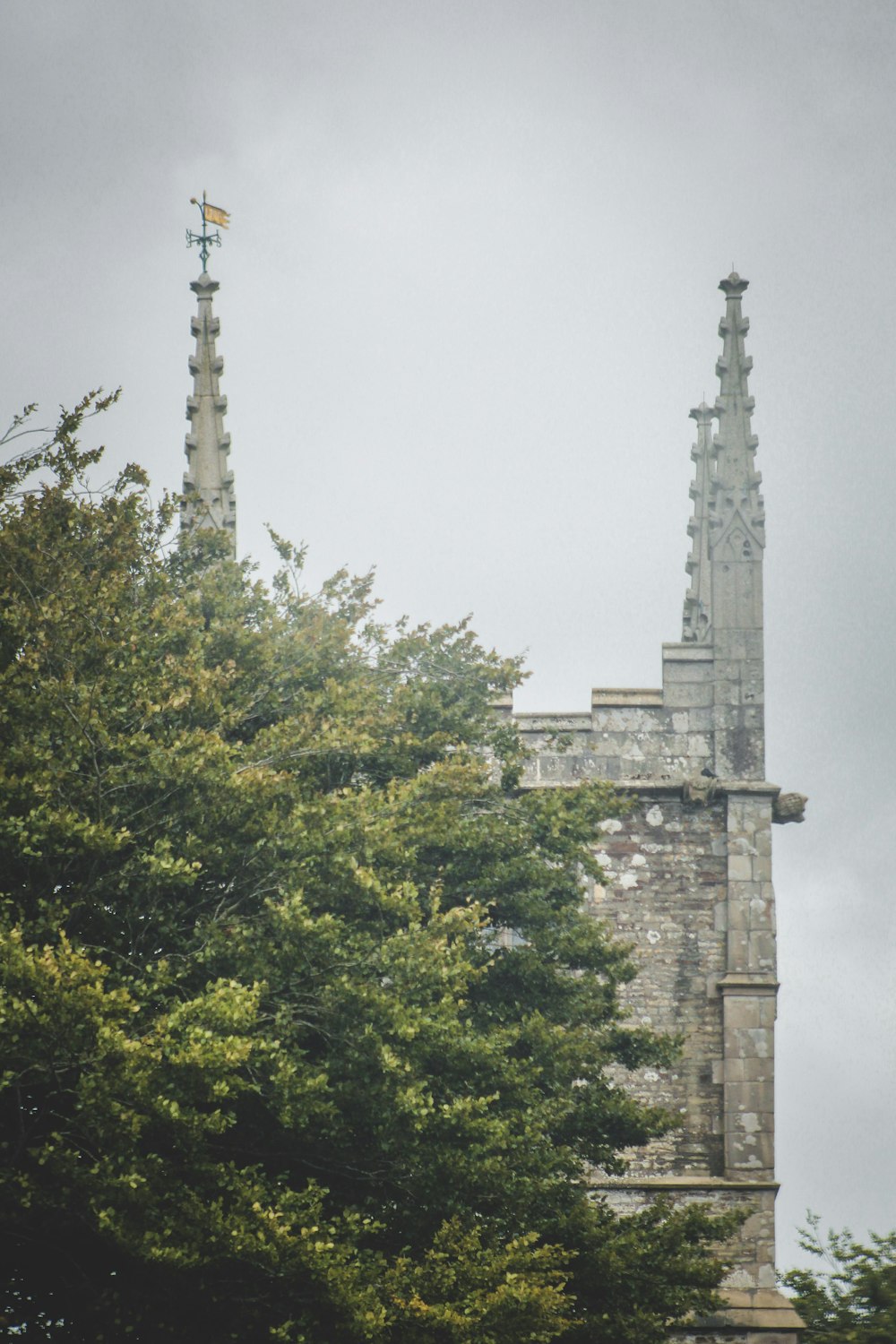 a tall stone building with a cross on top