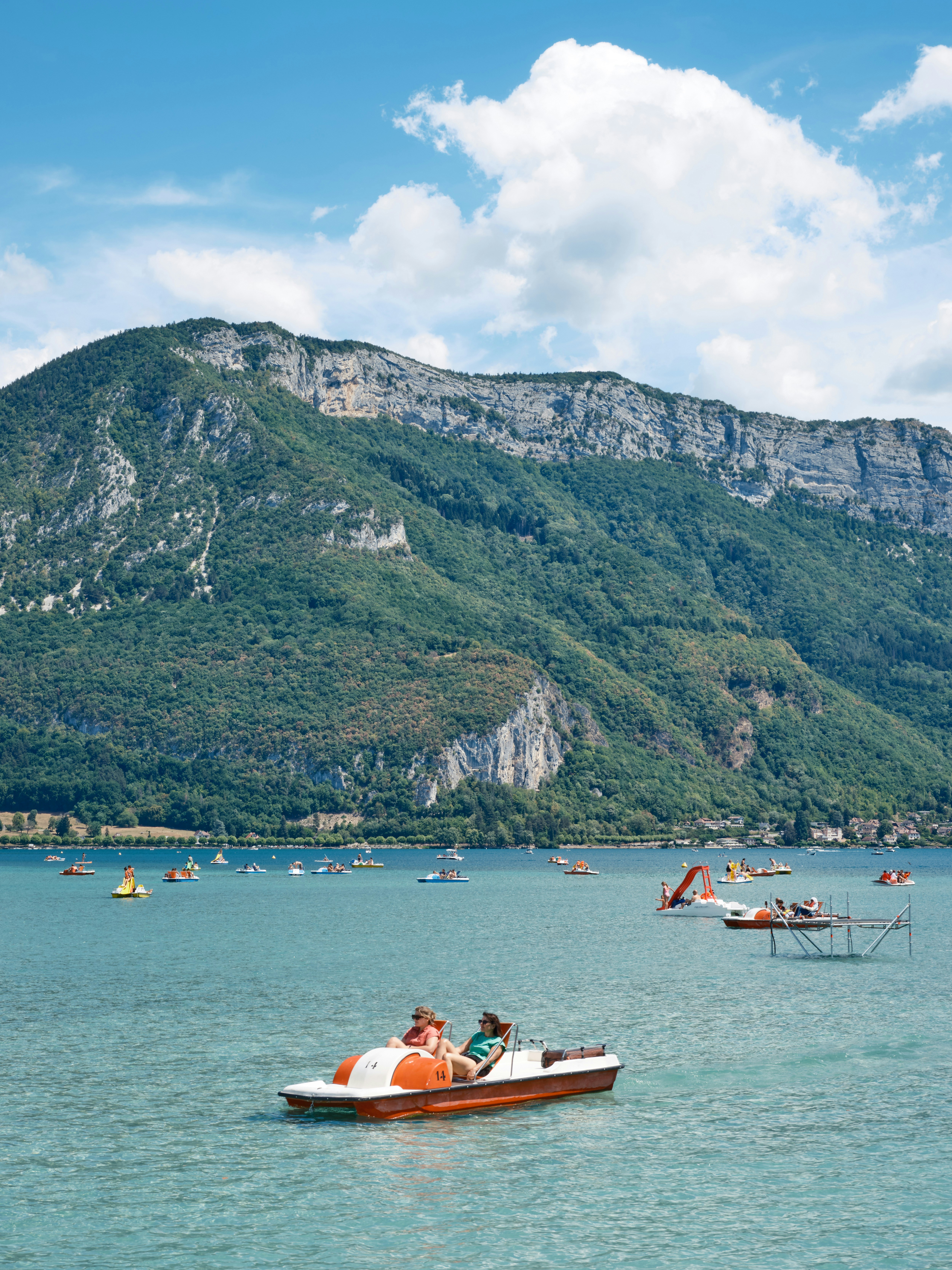 Un petit bateau dans un plan d’eau avec une montagne en arrière-plan ...
